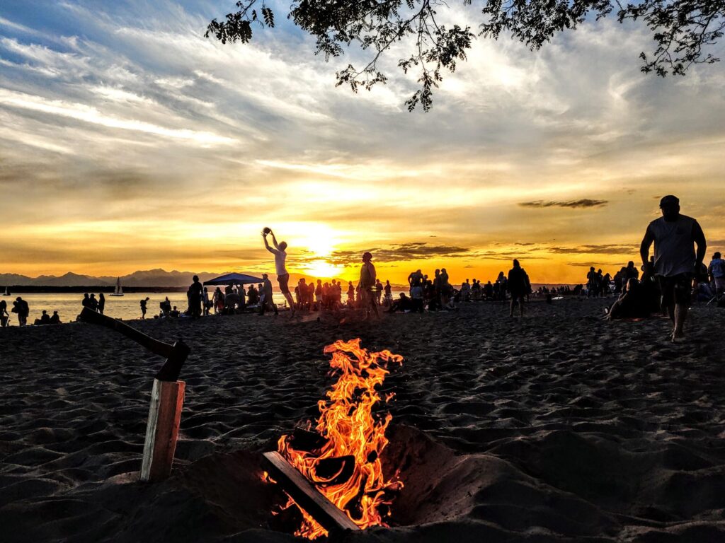 Golden Gardens Park visitors enjoying a beach fire during sunset